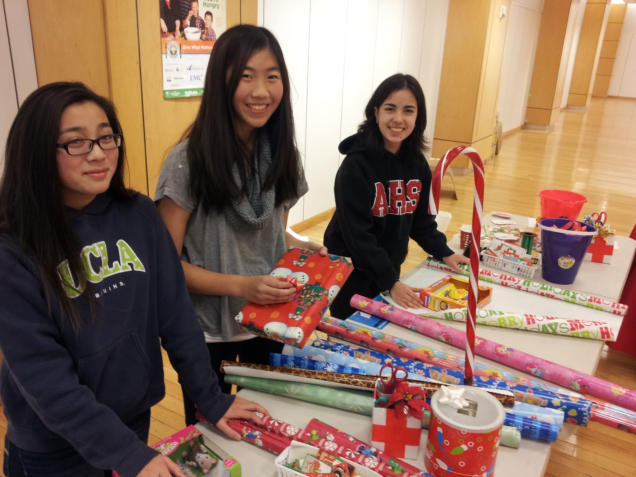teen volunteers at gift wrap station
